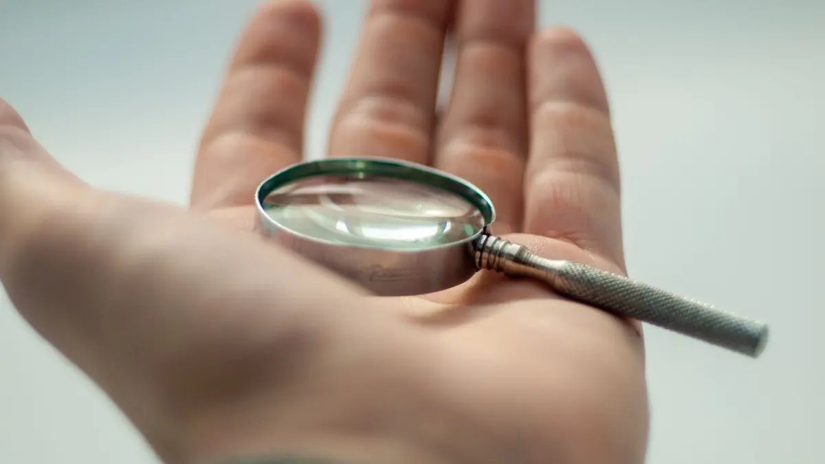 Main tenant une loupe pour examiner un avis iptv adulte de près