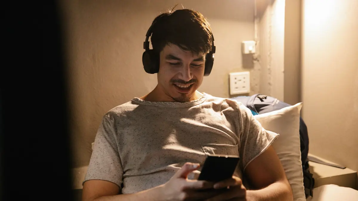 Casque et smartphone au lit pour un visionnage IPTV +18 sur mobile discret