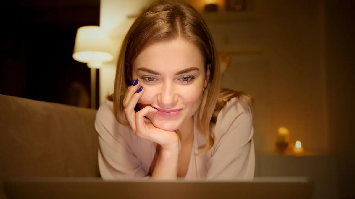 Femme souriante sur un canapé profitant d'un iptv adulte TiviMate bien réglé