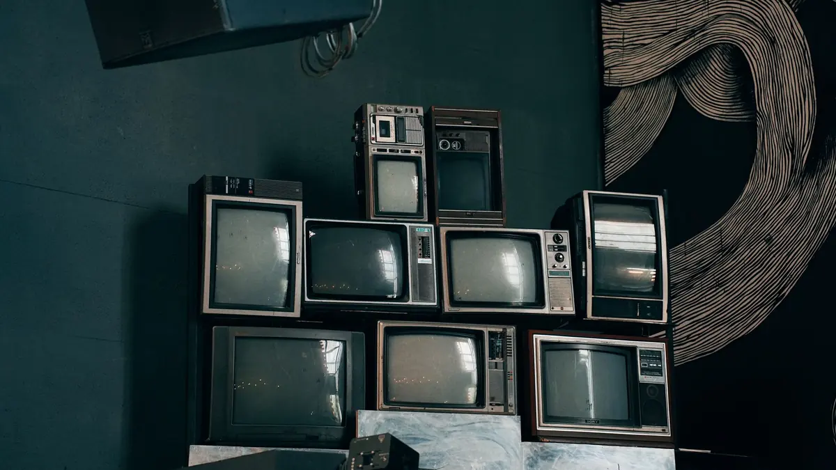 Pile de vieux téléviseurs rappelant les canaux fixes face au numéro chaîne X IPTV variable