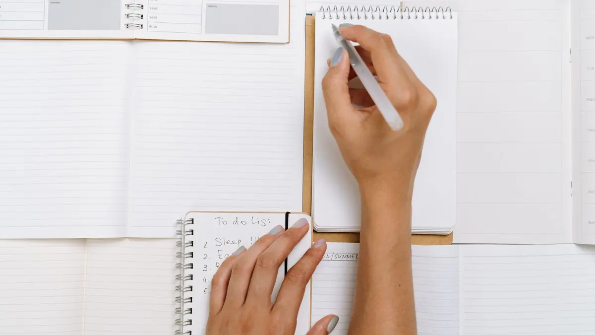 Main qui note dans un carnet la liste de chaque numéro chaîne X IPTV préféré